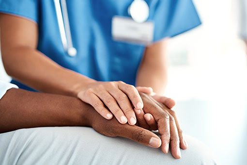 a nurse holding a patient's hand
